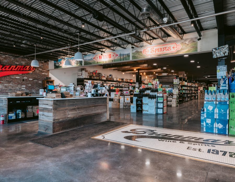 Branmar Wine and Spirits store interior with checkout counters, shelving, and a mosaic floor logo reading Est. 1972