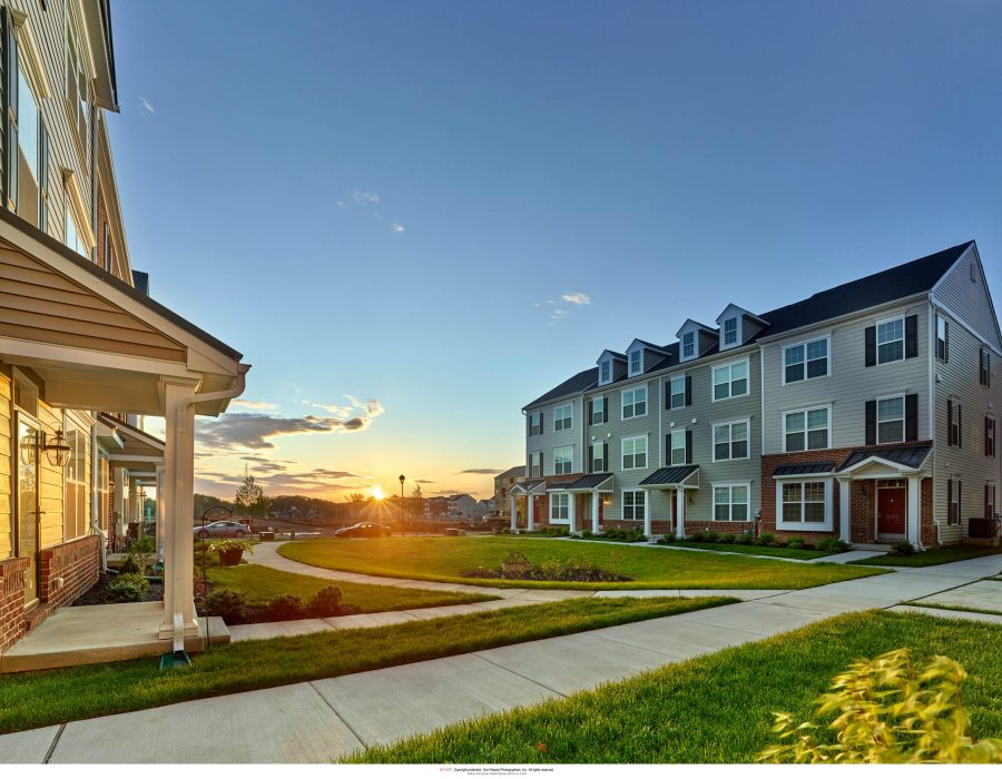 Townhomes at sunset with landscaped lawns and walkways at The Reserve at Darley Green