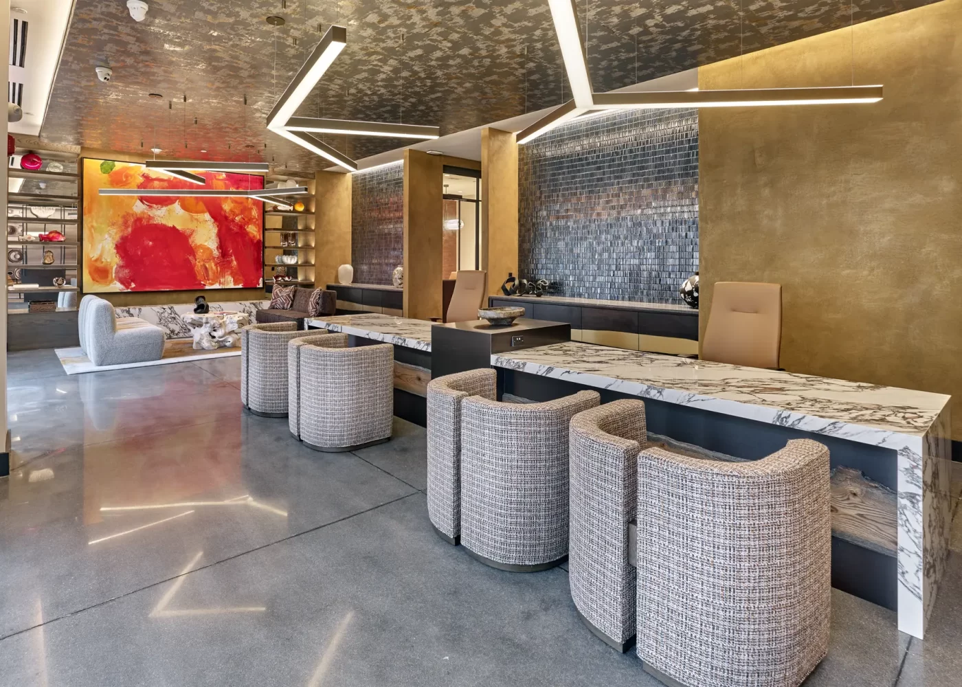 Modern lobby lounge with marble counters, tweed curved chairs, and a bold red abstract painting